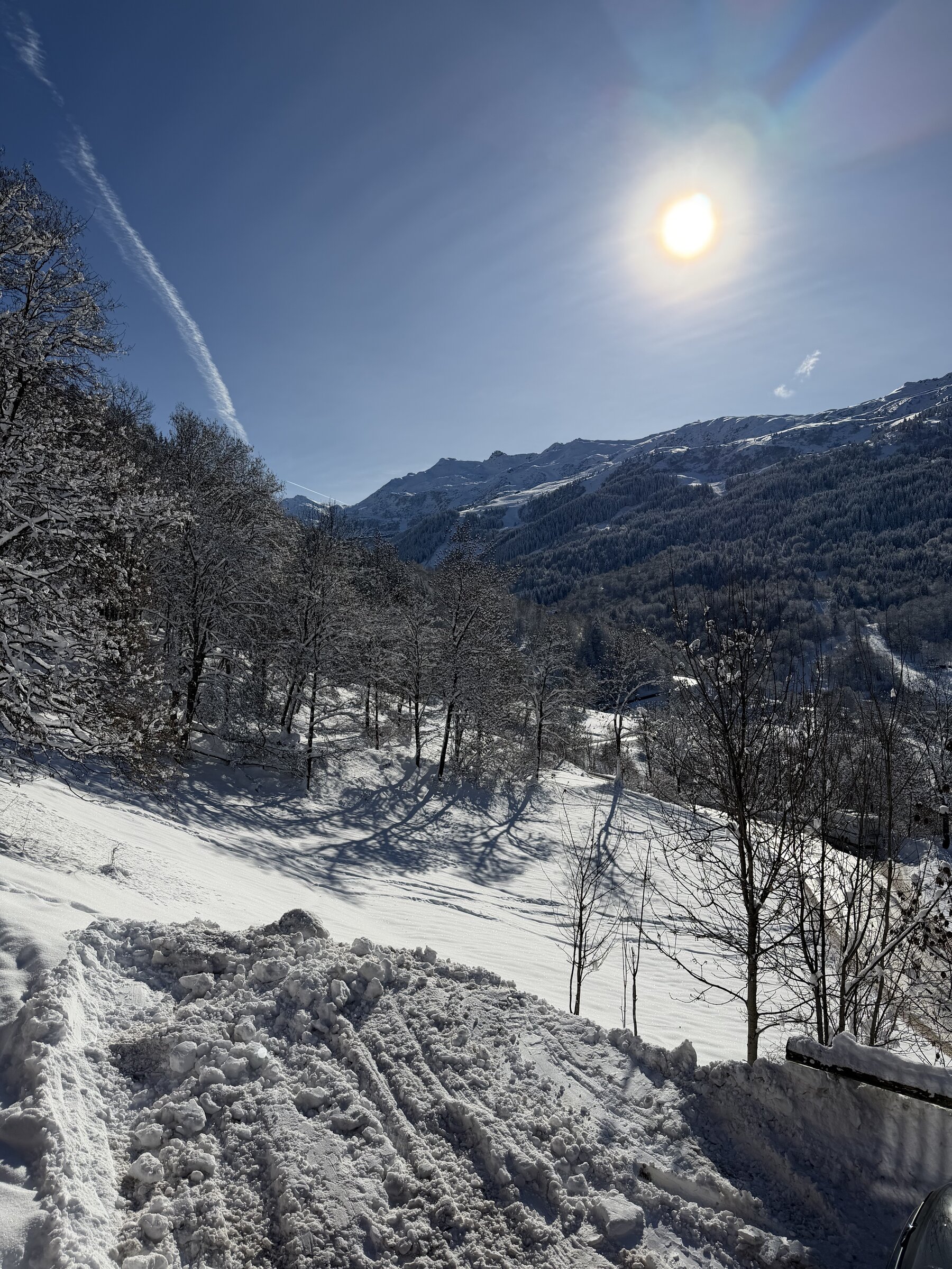 Skiers on the piste with the chalet and Méribel mountains behind